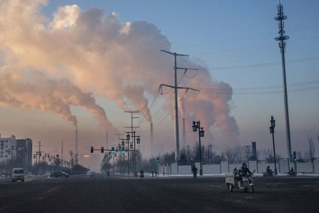 A new study estimates the annual financial toll from pollution-related premature births is a whopping $5.09 billion. Above, residents in Shanxi, China commute to work against a backdrop of smoke billowing from a coal- fired power plant.