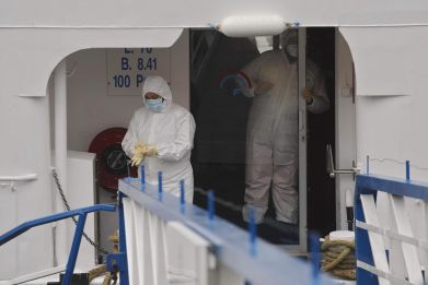 A worker disinfects a cruise ship in western Germany after a norovirus outbreak sickened hundreds.