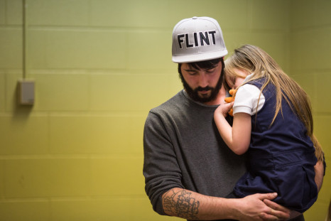 A resident of Flint, Michigan holds his daughter after she was tested for lead poisoning due to the contaminated water crisis.