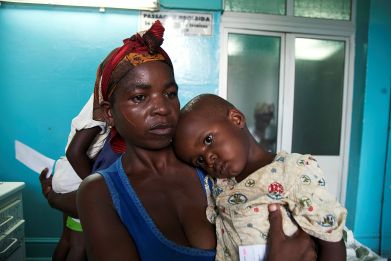 mother holds her child suffering from yellow fever at a hospital in Luanda​, Angola.