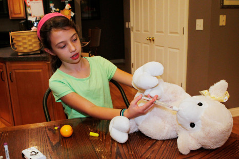 Audrey Stepp, 8, practices injecting a heroin antidote, naloxone, into her stuffed lamb Bill, at home in Sherpherdsville, Kentucky, November 18, 2015.