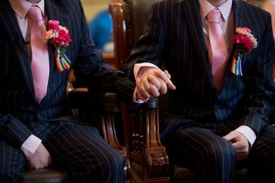 Phil Robathan (L) and James Preston (R) hold hands during their wedding ceremony in Brighton, southern England, on March 29, 2014