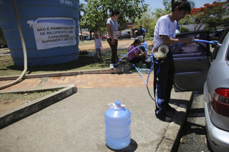 A Crohn's disease patient and resident of the region of Sao Paulo state that depends on the Cantareira water system, fills a water bucket from a water tank as the eight-month rationing of water continues as a result of a record drought, in Itu, Oct. 28, 2014.