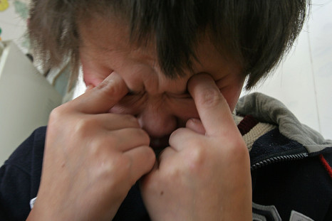 A child suffering from infantile autism reacts during rest at the Xining Orphan and Disabled Children Welfare Center in Xining of Qinghai Province, China, Dec. 17, 2005.