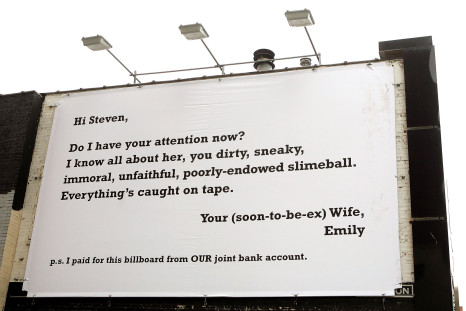 A passerby photographs a billboard claiming to be from an unhappy wife railing against her husband's infidelity in Chicago, July 21, 2006.