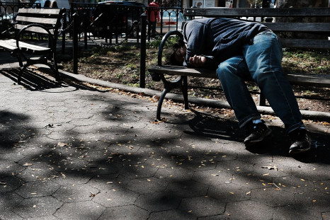 A man lies on a bench in a neighborhood park with a high rate of poverty and illegal drug use in New York City, Oct. 14, 2016.