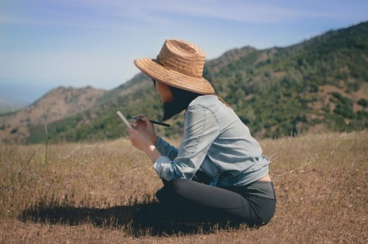 Woman writing in field