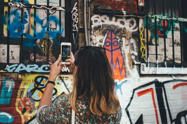 Woman taking pic of graffiti