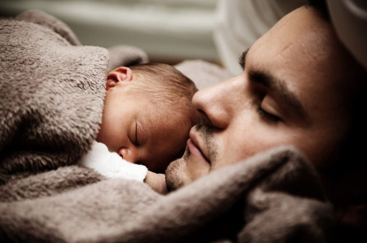 man and baby sleeping