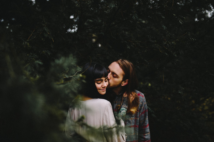 Man kissing woman in the woods