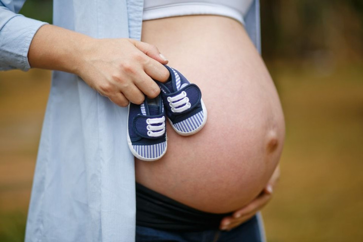 pregnany woman holding shoes
