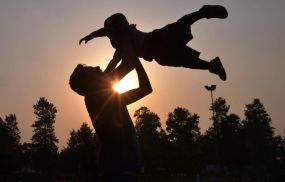 Indian father Shailesh throws up his son, Harish, at a park in Amritsar on June 19, 2016, on Father's Day, a day observed in many countries to celebrate fathers and fatherhood.New study shows that many men have been receiving less attention when dealing with postpartum depression after childbirth due to stigma.