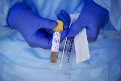 A medical staff displays a test kit to detect the novel coronavirus at a COVID-19 screening-drive, at the Amsterdam UMC in Amsterdam The Netherlands, on March 24, 2020.