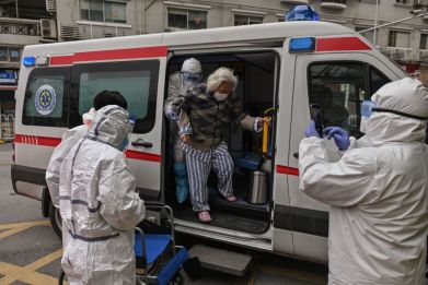 An elderly woman arrives in an ambulance to Wuhan Red Cross Hospital after being transferred from another hospital after recovering from the COVID-19 coronavirus in Wuhan on March 30, 2020.