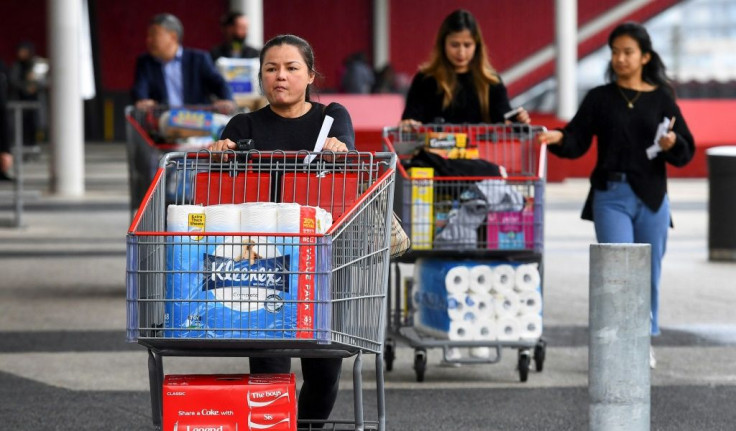 people-leave-a-costco-warehouse-with-rolls-of