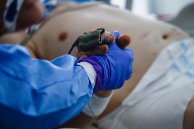 A nurse wears a protective, suit, mask, goggles and gloves as she grabs the hand of an unconscious patient inside the Intensive Care Unit (ICU) for COVID-19 patients of Krakow's University Hospital on April 17, 2020 in Krakow, Poland. Considered the largest and most modern medical centre in Poland, Krakow University Hospital is one of the designated hospitals to treat COVID-19 patients by the government.