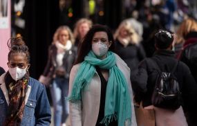 A woman wears a face mask while walking on Oxford Street on April 01, 2022 in London, England.