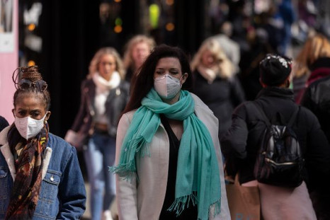 A woman wears a face mask while walking on Oxford Street on April 01, 2022 in London, England.