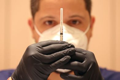 Jatniel Hernandez fills syringes with COID-19 vaccine booster shots at a COVID-19 vaccination clinic on April 06, 2022 in San Rafael, California.