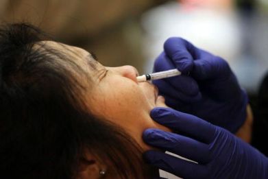 A woman receives an H1N1 flu nasal spray vaccination during a clinic at the Bill Graham Civic Auditorium December 22, 2009 in San Francisco, California.