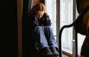 Depressed Woman Sitting by the Window