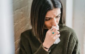 Depressed woman with tissue in room